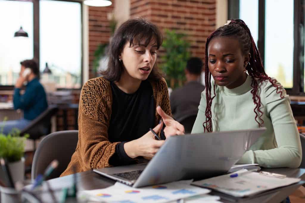 Two women sitting side by side in front of a computer