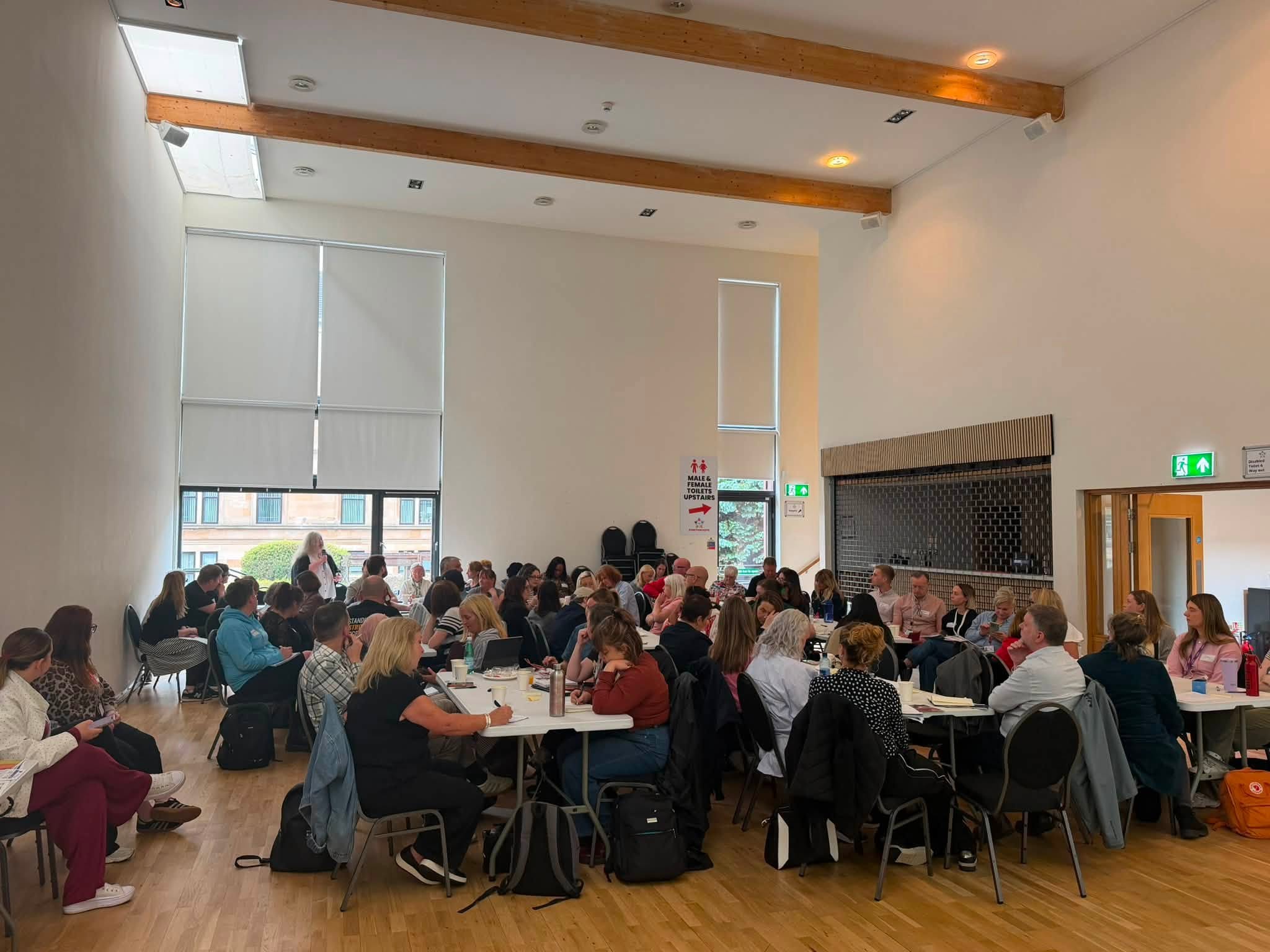Photo taken from a Glasgow networking session busy with attendees listening to a speaker